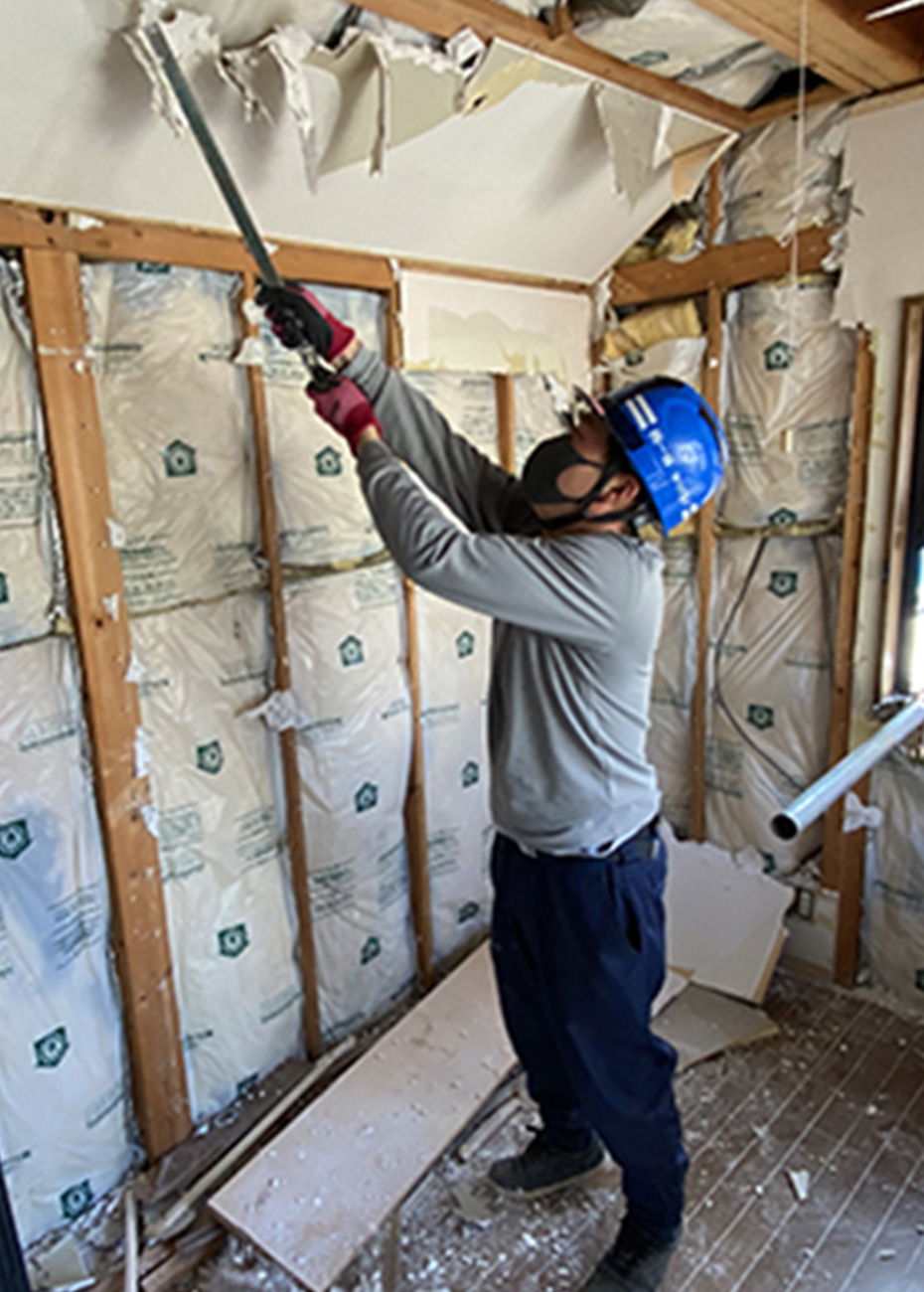 室内の石膏ボードを解体する作業員